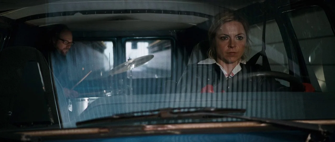 Sound of Noise (2010) movie still: medium — The interior of a passenger van viewed from the front passenger area. A woman operates the steering…