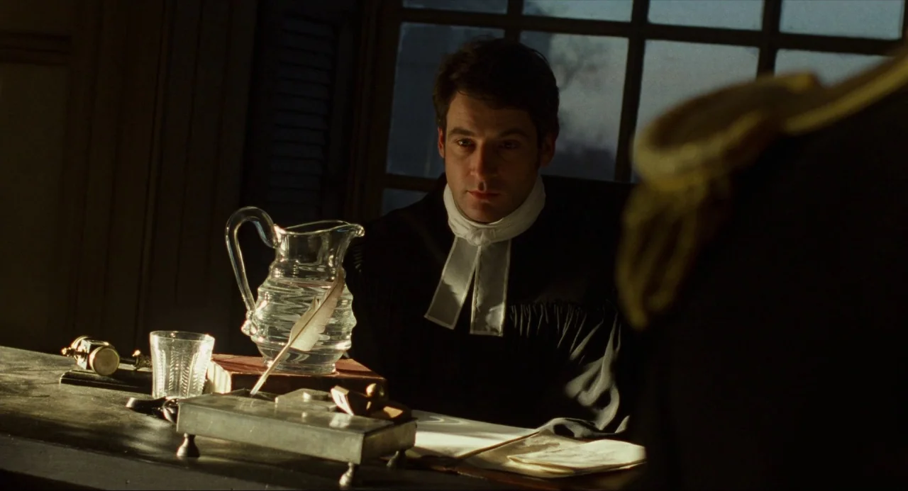 Amistad (1997) movie still: medium — A dark, wood-paneled room features a desk set with a glass carafe and stationery. A man in clerical vestments…