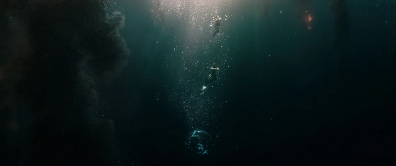 Jurassic World: Fallen Kingdom (2018) movie still: wide — The deep, dark expanse of open water is filled with rising bubbles and debris. Three small…