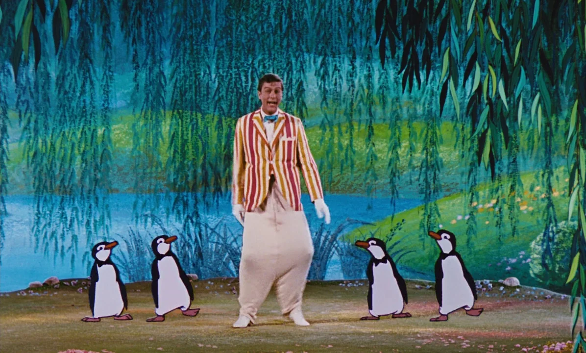 Mary Poppins (1964) movie still: fullbody — A man interacts with hand-drawn animated penguins against a vibrant painted landscape backdrop. The…