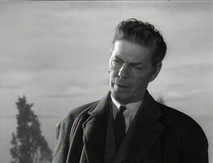 The Devil’s Eye (1960) movie still: medium — An outdoor field with a single tree stands behind an older man. The man is looking slightly to the side…