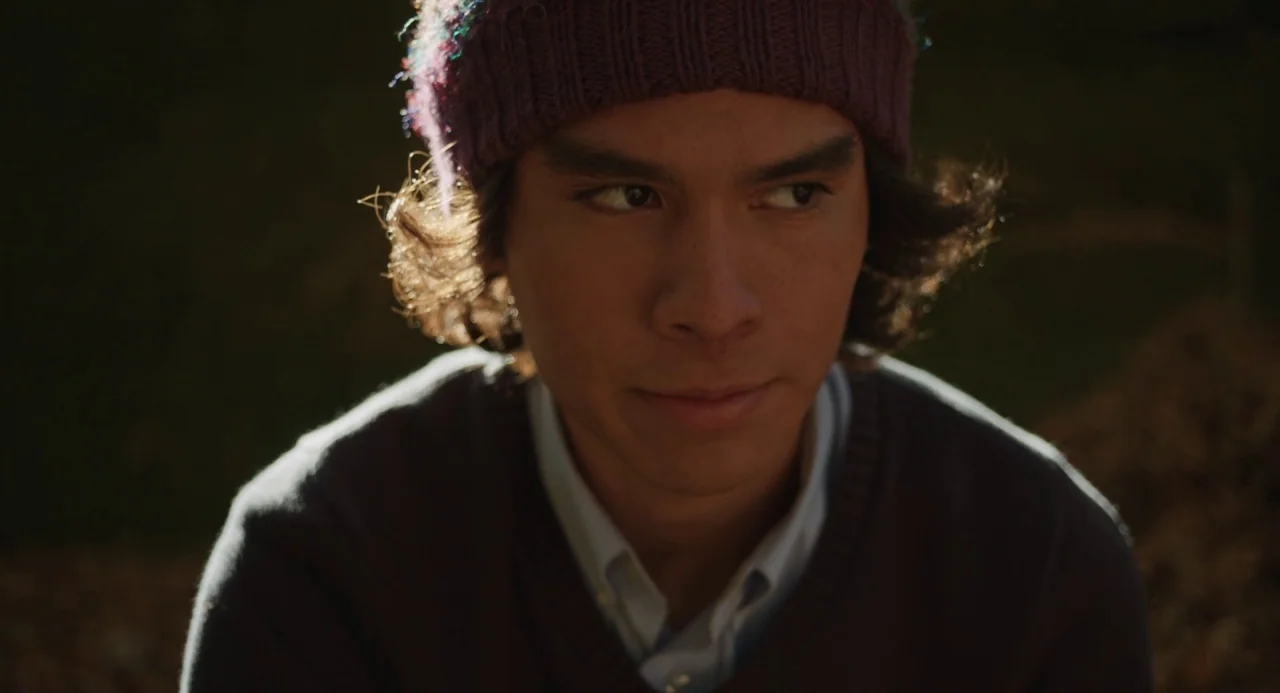 The Miseducation of Cameron Post (2018) movie still: closeup — A dark, out-of-focus natural background surrounds the subject during late afternoon…