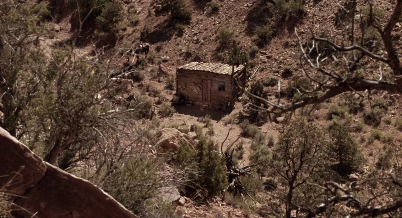 Ride In The Whirlwind (1966) movie still: establishing — A remote, dilapidated wooden shack stands nestled within a dry, arid, rocky desert canyon.…