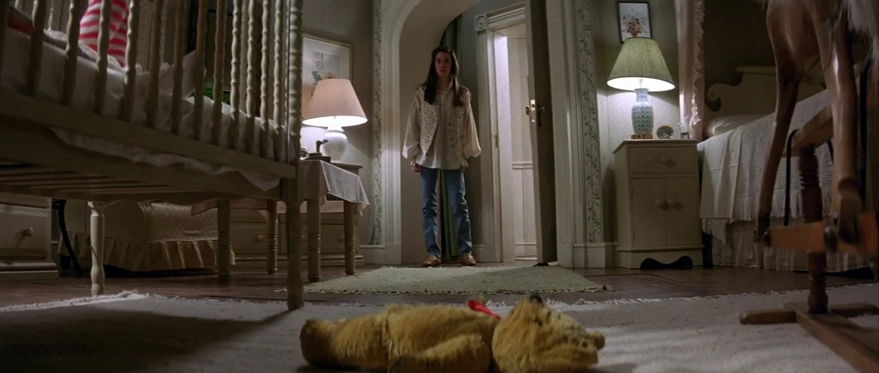 Labyrinth (1986) movie still: wide — A 1980s nursery contains a wooden crib, a rocking horse, and two nightstands. A girl stands in the doorway…