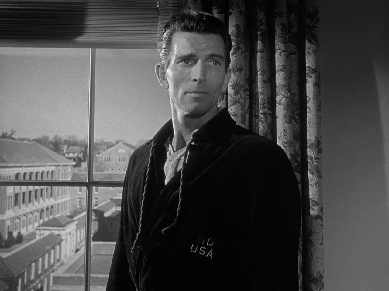 The Day the Earth Stood Still (1951) movie still: medium — A hospital room with a large window looking out onto a multi-story building. A man in a…