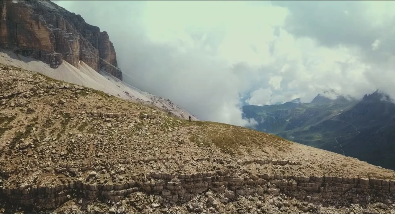 Crooked Trees Gon Give Me Wings (2022) movie still: establishing — A rugged high-altitude mountain ridge is composed of jagged rock and sparse…