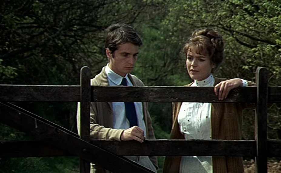 Two English Girls (1971) movie still: medium — A man and woman stand behind a rustic wooden gate in a wooded area. They look toward each other while…