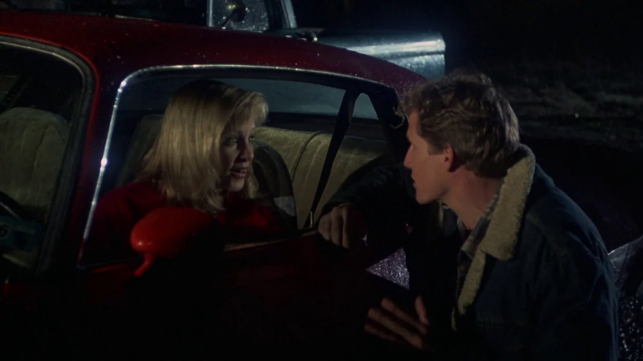 Friday the 13th Part VI: Jason Lives (1986) movie still: medium — A dark night setting at an outdoor location with two individuals near a red…