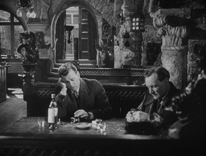 The Third Man (1949) movie still: medium — A dark, rustic stone-walled tavern features arched stone doorways and decorative hanging lanterns. Two…