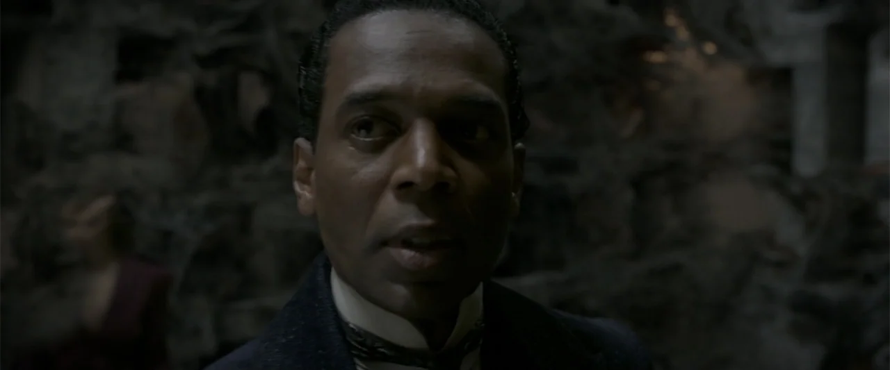 Fantastic Beasts: The Crimes of Grindelwald (2018) movie still: closeup — A dimly lit, textured stone or decorative interior provides a dark…