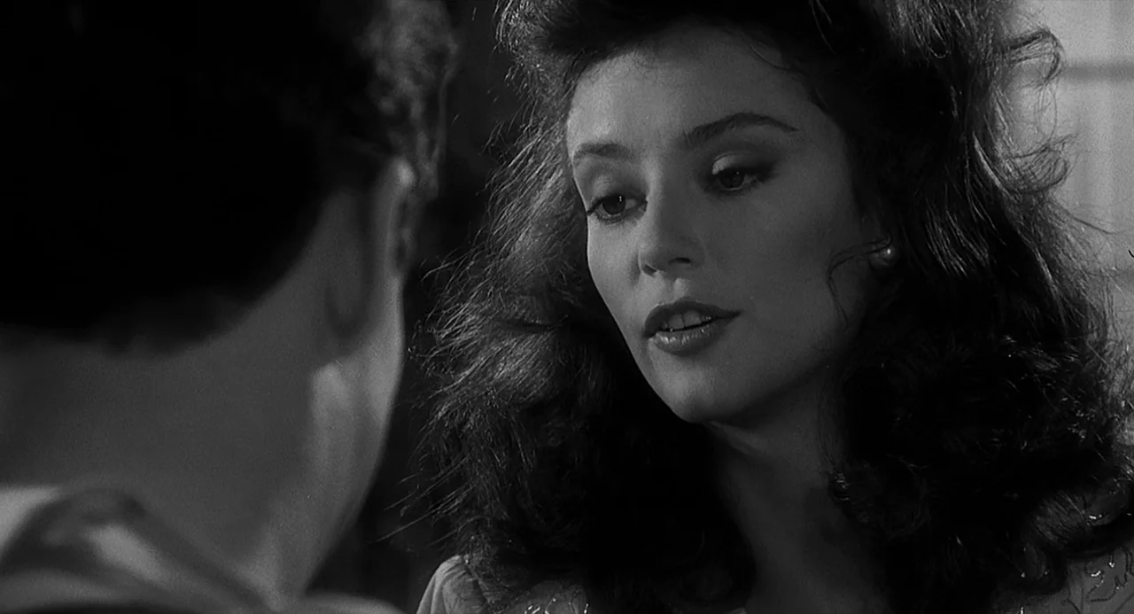 Dead Men Don’t Wear Plaid (1982) movie still: closeup — A close-up of a woman in an indoor setting with dark background elements. She turns her head…