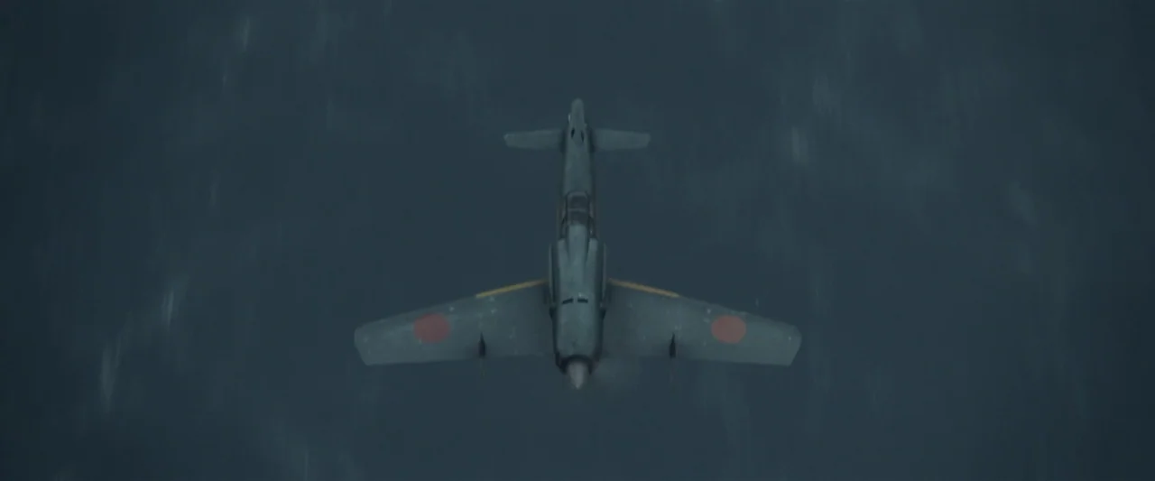 Godzilla Minus One (2023) movie still: wide — A single-engine military aircraft flies directly over dark, choppy water. The plane is seen from a…