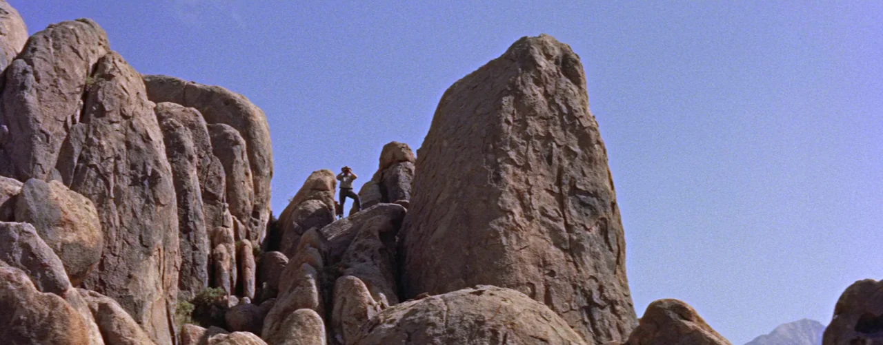Bad Day At Black Rock (1955) movie still: wide — Massive granite boulders cluster together in an arid, high-altitude mountain terrain under clear…