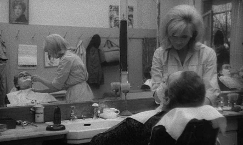 Man Is Not Bird (1965) movie still: medium — A classic barbershop setting with a large wall-mounted mirror and white porcelain sink basin. A…