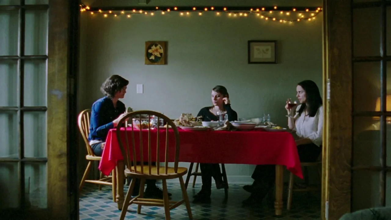 I Am Not a Serial Killer (2016) movie still: wide — A residential room features a dinner table set with food and a red cloth. Three women sit in…