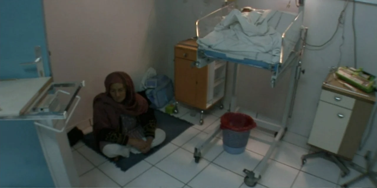 Silencing the Song: An Afghan Fallen Star (2011) movie still: medium — A spare hospital room features white tile flooring and medical equipment near…