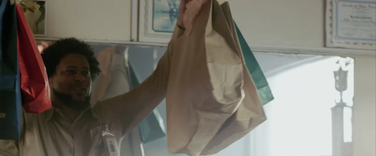 La Musiquita por Dentro (2019) movie still: medium — An office interior features beige walls adorned with framed certificates and a trophy display.…
