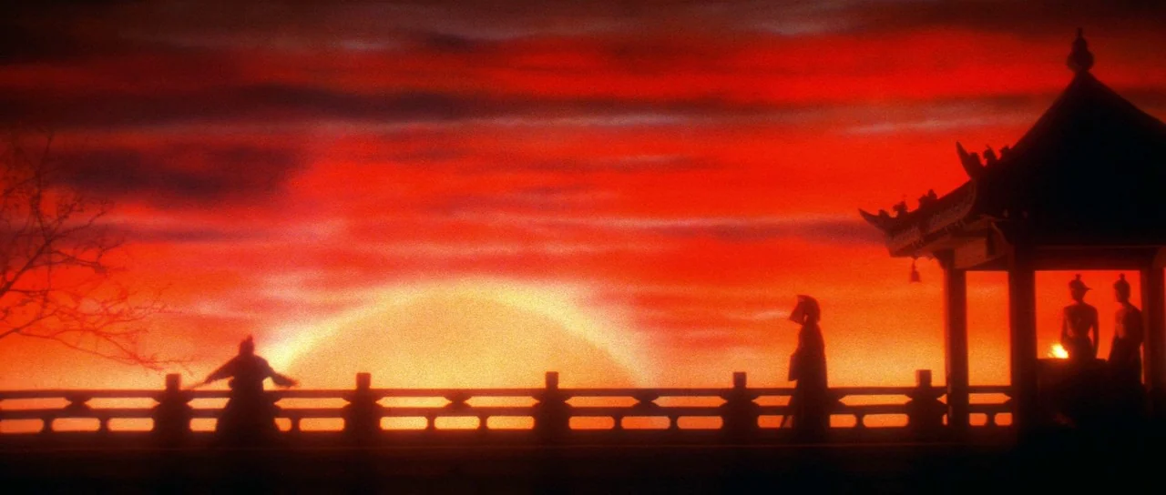 The Bride With White Hair (1993) movie still: wide — A silhouette of a traditional Asian pavilion stands against a bright orange sunset sky. Three…
