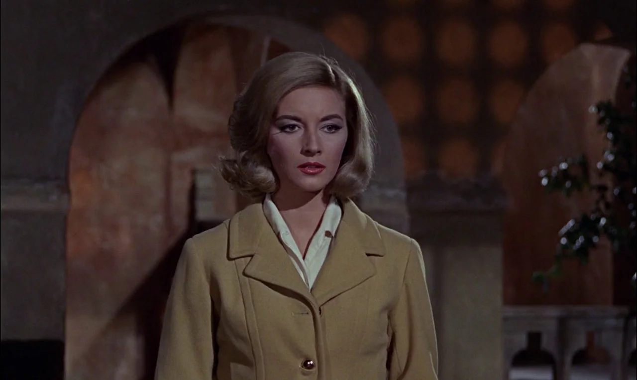 From Russia With Love (1963) movie still: medium — A dimly lit passage features dark stone arched doorways and architectural stone accents. A blonde…