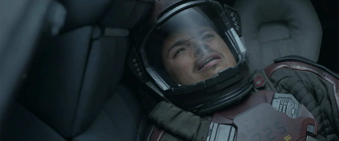 DISTANT (2026) movie still: closeup — A high-tech pilot seat inside a dark spacecraft cockpit with complex instrument panels visible. A young male…