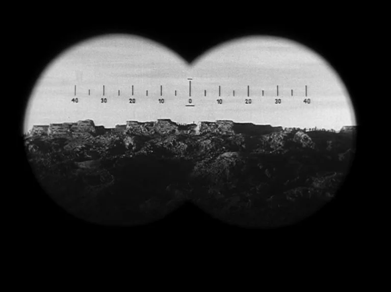 Paths of Glory (1957) movie still: establishing — A war-torn landscape viewed through a binocular reticle showing distant earthen fortifications.…