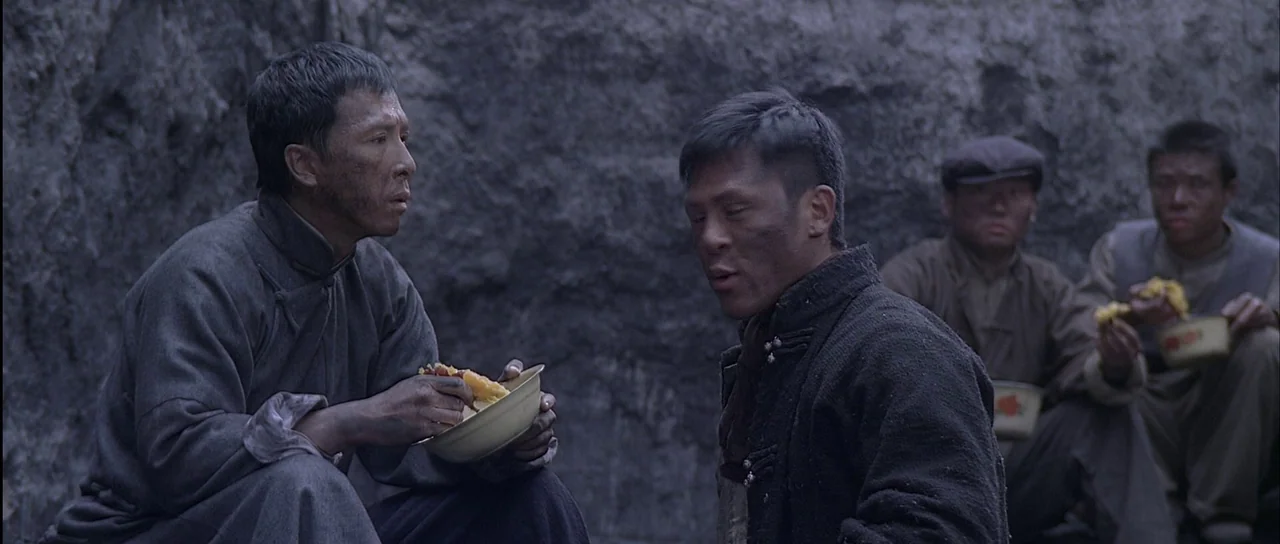 Ip Man (2008) movie still: medium — A dirt-walled dugout trench serves as a makeshift area for a group of men. Two men in the foreground crouch and…