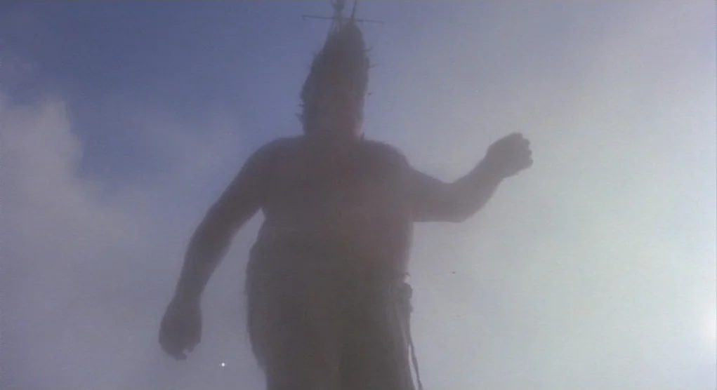 Time Bandits (1981) movie still: fullbody — A man stands on a deck obscured by dense fog against a blue sky. The camera looks upward at the…