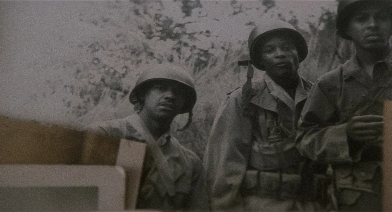 Devil In A Blue Dress (1995) movie still: medium — A vintage black and white photograph depicts three soldiers in combat gear. The men stand among…