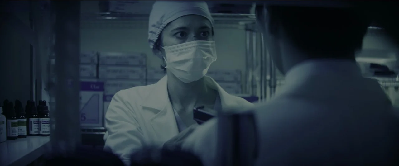 Kate (2021) movie still: medium — A cluttered room containing shelves filled with rows of small brown medical bottles. A woman in a lab coat and…