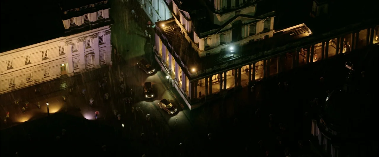Now You See Me 2 (2016) movie still: establishing — A high-angle view of a dark, rain-slicked neoclassical plaza at night with classic architecture.…