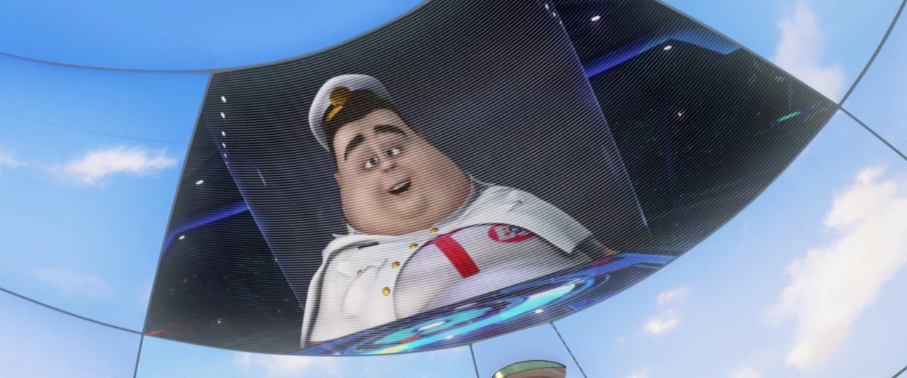 Wall-E (2008) movie still: closeup — A curved digital display screen hangs in a bright, outdoor setting against blue skies. A cartoonish, heavy-set…