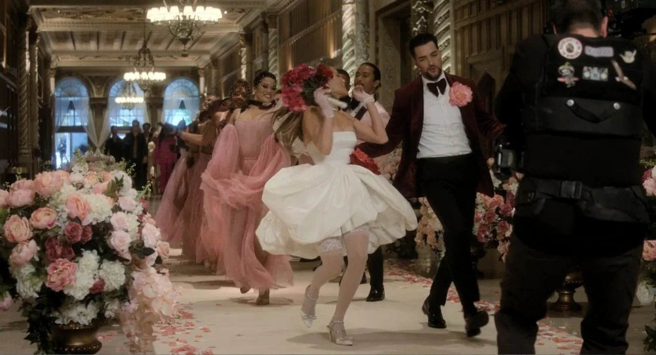 The Greatest Love Story Never Told (2024) movie still: fullbody — A decorated corridor featuring arched windows and large floral arrangements on the…