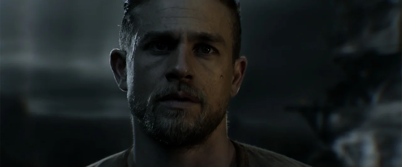 King Arthur: Legend of the Sword (2017) movie still: closeup — A dark outdoor space at night with an indistinct, blurry landscape in the background.…