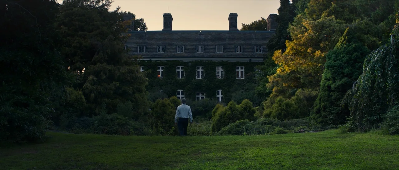 You Were Never Really Here (2017) movie still: wide — A large stone manor covered in climbing ivy sits at the end of a lawn. A man walks across the…