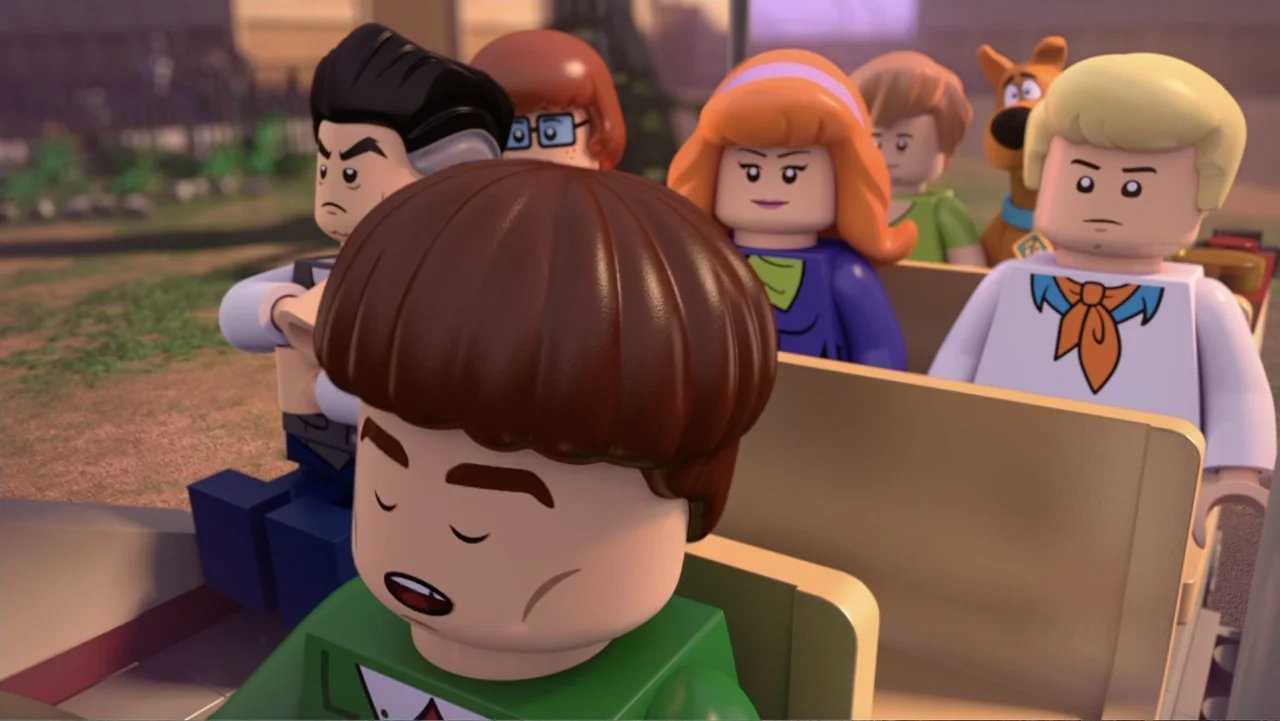 LEGO Scooby-Doo! Haunted Hollywood (2016) movie still: medium — The interior of an open-air transport vehicle carrying a group of Lego characters.…