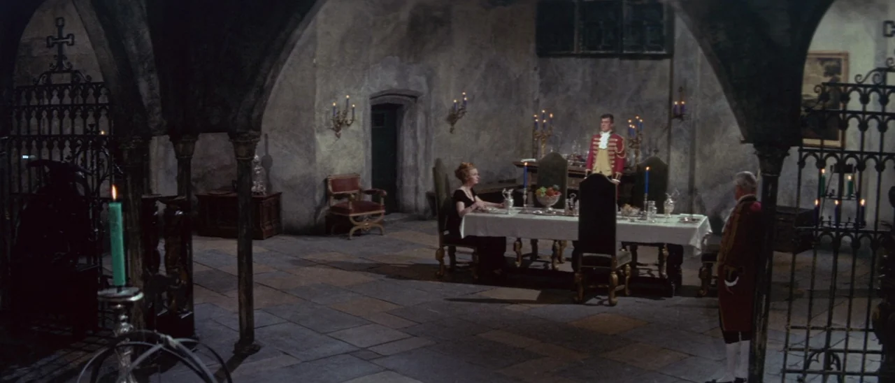 The Tomb of Ligeia (1964) movie still: wide — A stone-walled medieval-style dining hall features vaulted ceilings and tiled floors. Three…