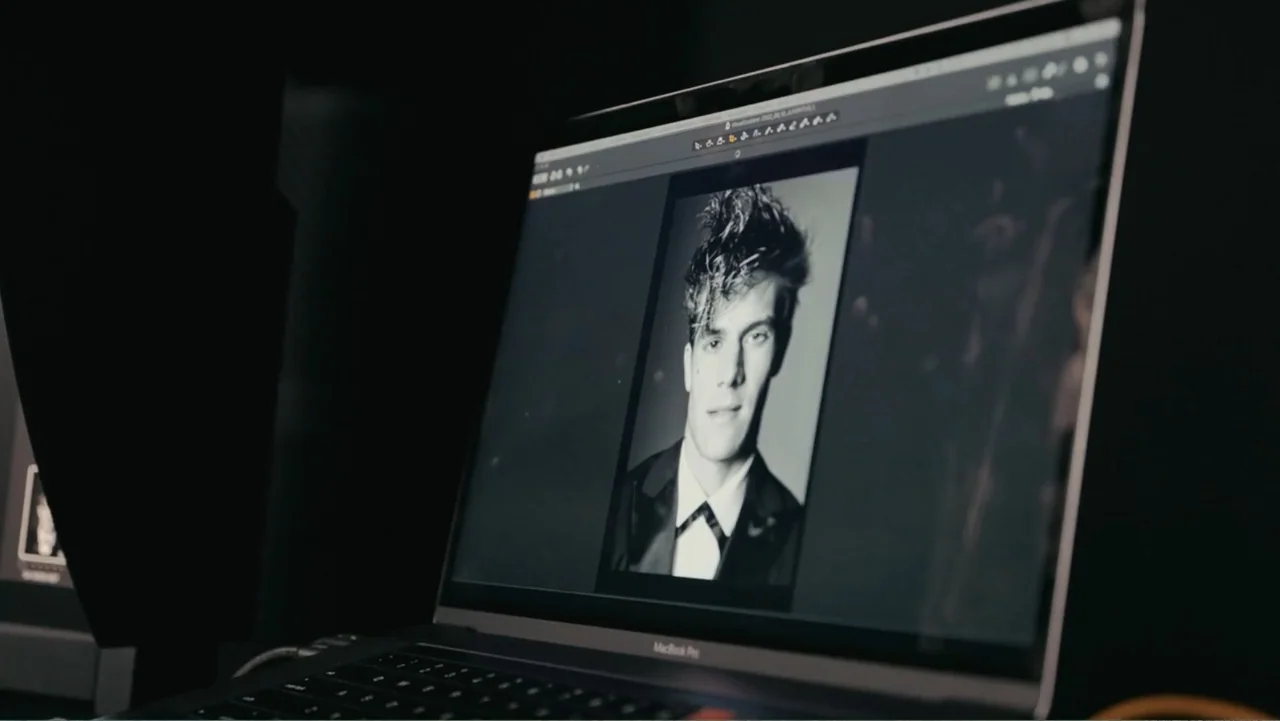 FRAGILE - The story of Nicolò Fagioli (2024) movie still: medium — A dark workspace features a single laptop open on a desk. The screen displays a…