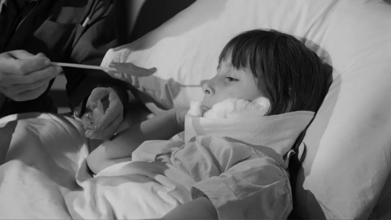 Escuela para solteras (1965) movie still: medium — A clinical environment features a young child resting in a hospital bed with pillows. The child…