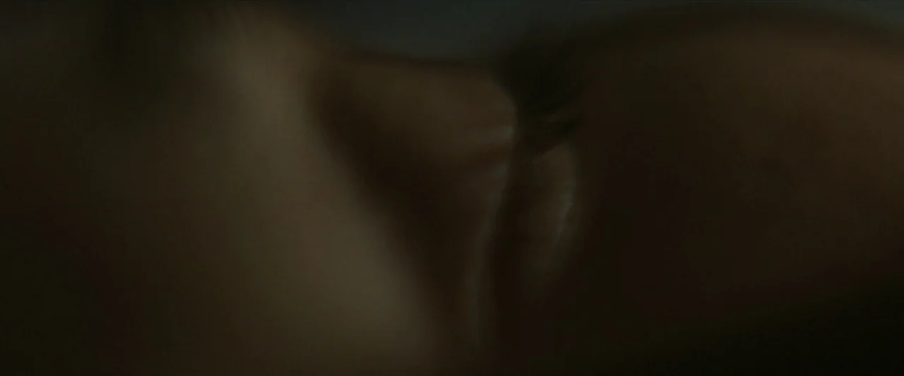 For Ellen (2012) movie still: closeup — A dark, dimly lit indoor setting focuses on the texture of human skin. A person lies with their eyes closed…