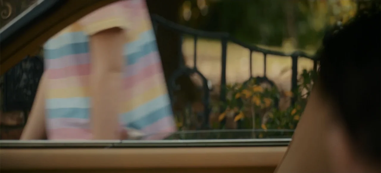 My Best Friend's Exorcism (2022) movie still: medium — A view from inside a car looking out through an open side window. A child in a striped shirt…