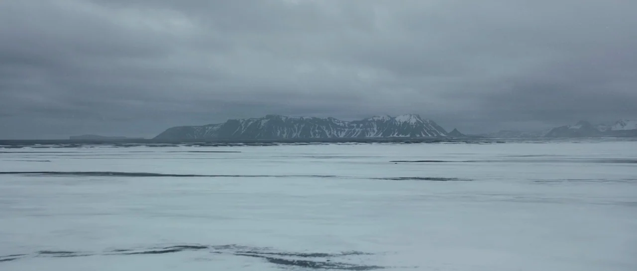 Captain America: Civil War (2016) movie still: establishing — A vast, frozen plain stretches toward a distant range of snow-capped mountains.…