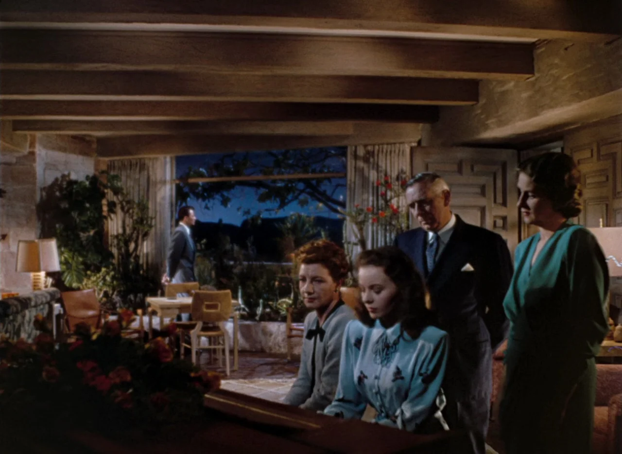 Leave Her To Heaven (1945) movie still: medium — A spacious room features exposed ceiling beams and a large window looking out onto a dark garden.…