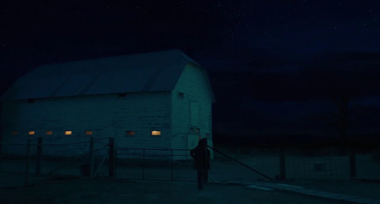 Fast Color (2018) movie still: wide — A white wooden barn stands at night under a clear starry sky. Small windows along the side of the structure…