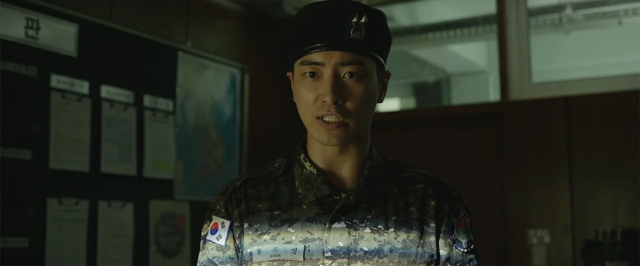 Along with the Gods: The Two Worlds (2017) movie still: medium — A dark military room features a black bulletin board covered with white paperwork…