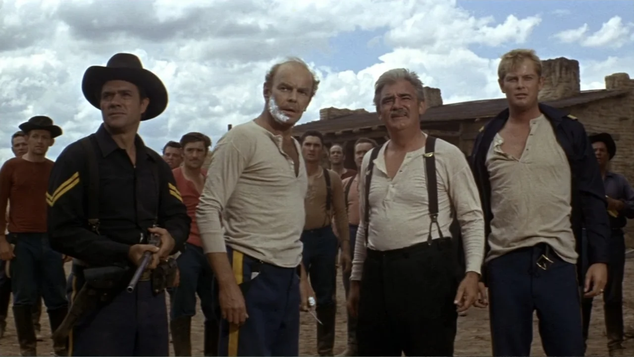 A Distant Trumpet (1964) movie still: medium — A dusty outdoor clearing features several men dressed in nineteenth century work wear clothing. The…