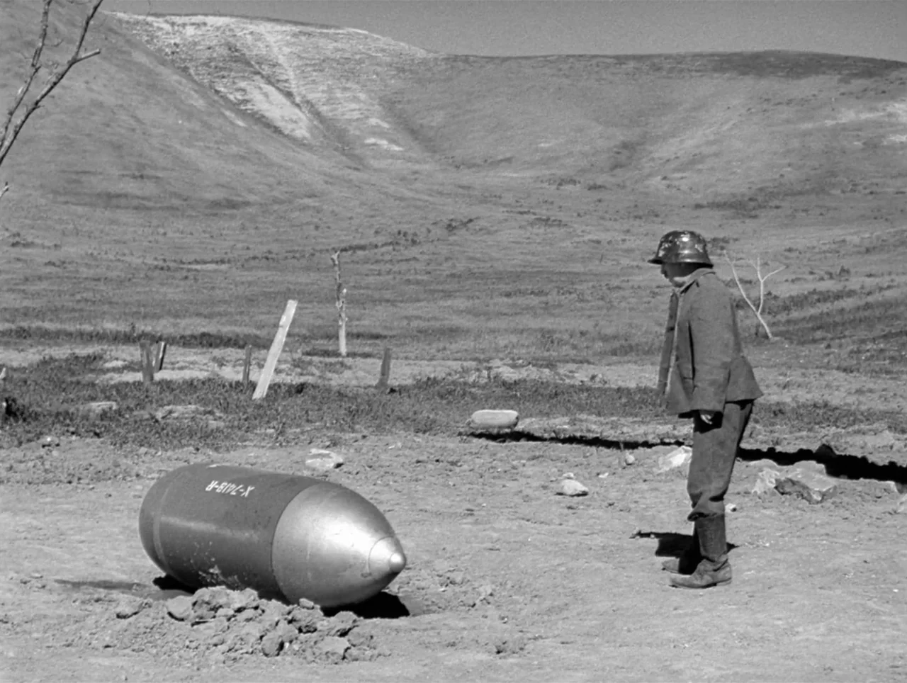 The Great Dictator (1940) movie still: fullbody — A vast, barren landscape of dry earth and rolling hills under a bright sun. A man in military…