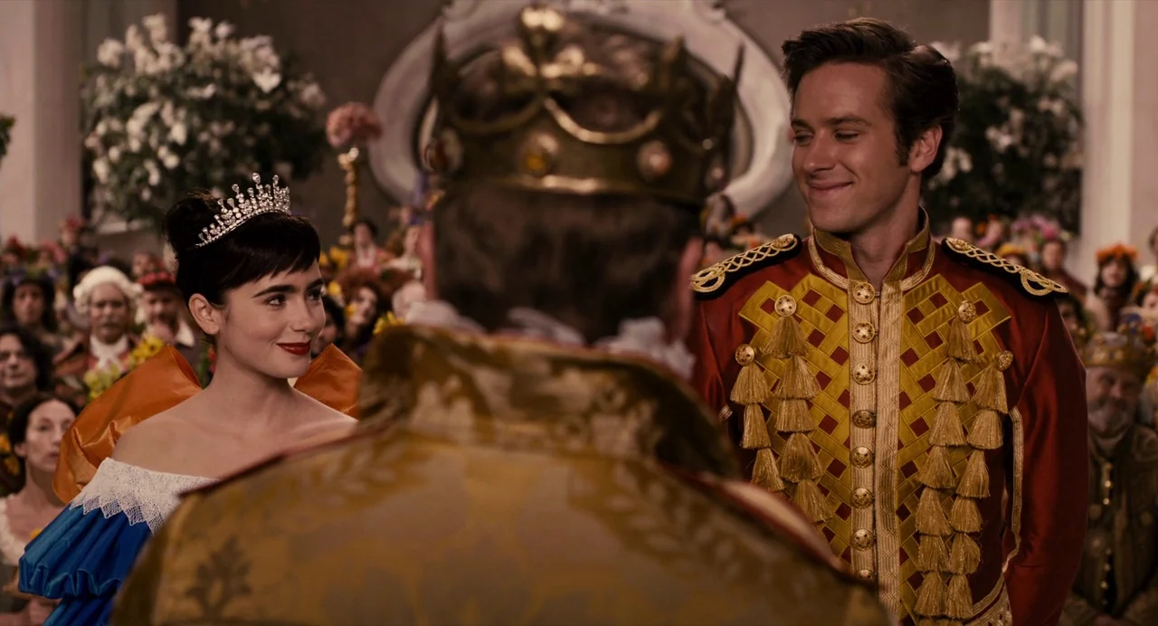 Mirror Mirror (2012) movie still: medium — An ornate ballroom is filled with guests witnessing a royal wedding celebration. A woman and a man in…