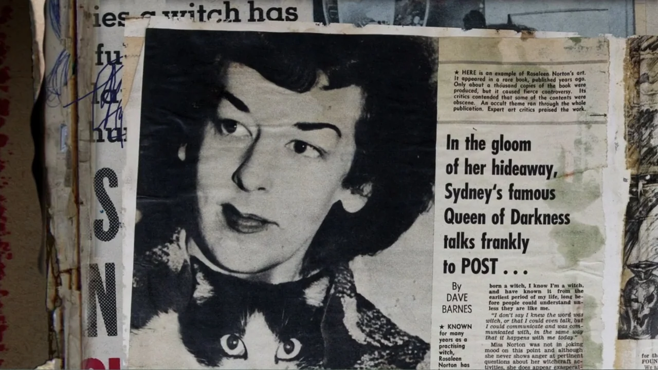 The Witch of Kings Cross (2020) movie still: closeup — A close-up view of a printed newspaper article featuring a woman's portrait photograph. The…