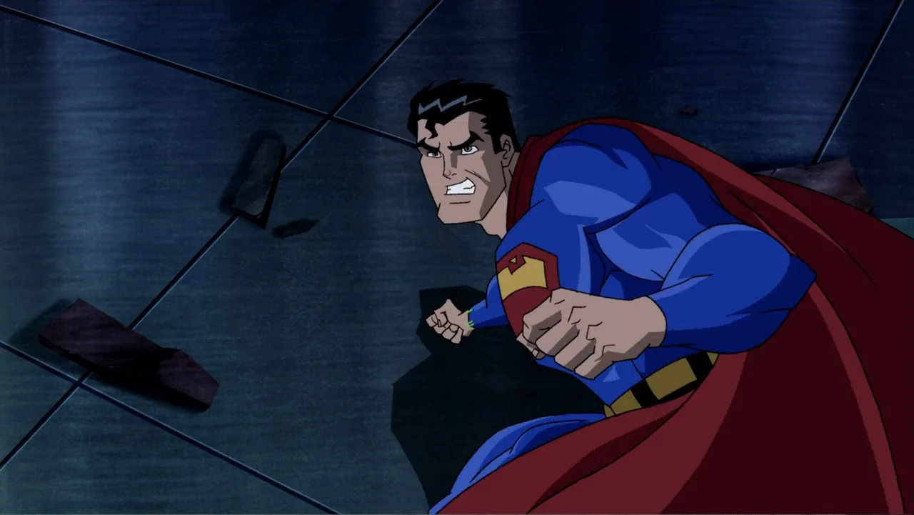 Superman/Batman: Public Enemies (2009) movie still: medium — A dark tiled interior floor features cracks and scattered rubble pieces near a wall.…
