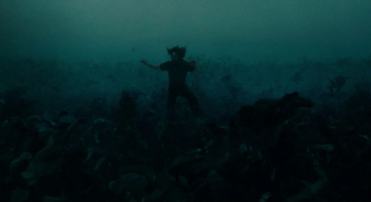 Noah (2014) movie still: wide — A dark, murky body of water is filled with numerous floating human corpses. A single man treads water near the…